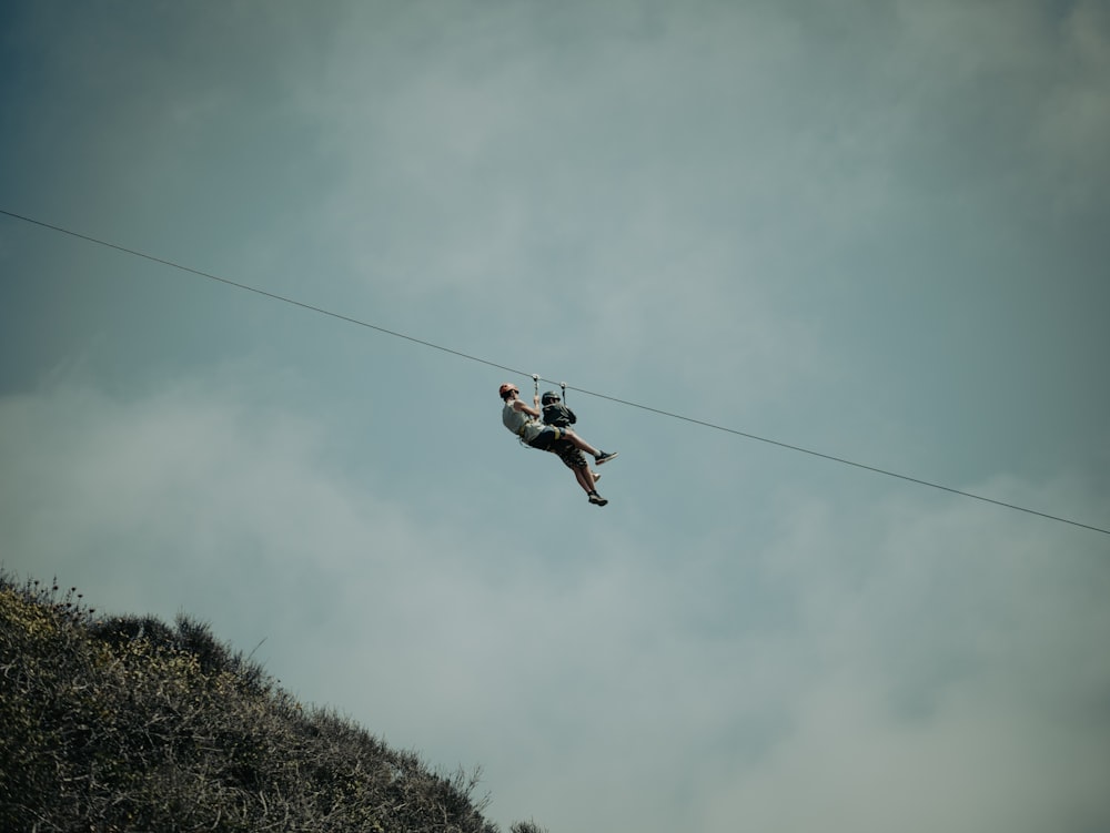 a man is high in the air on a rope