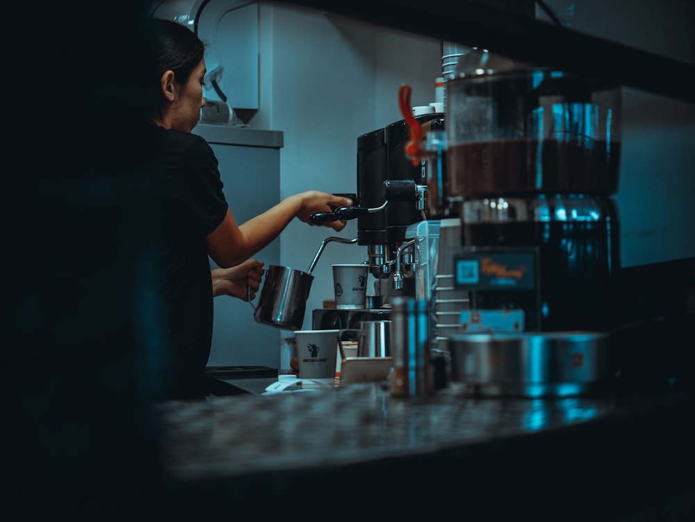 a woman is making a cup of coffee