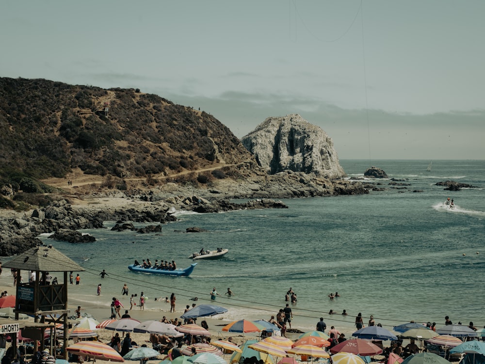 a group of people standing on top of a beach next to the ocean