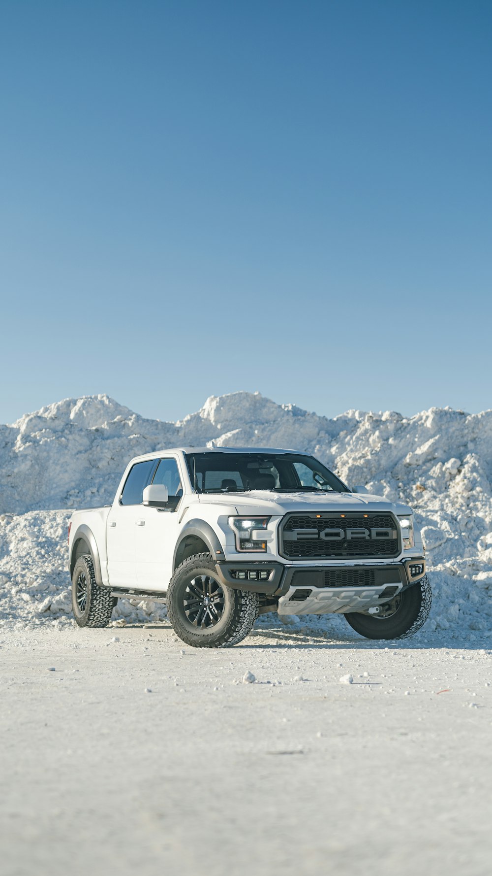 a white truck parked on top of a snow covered field