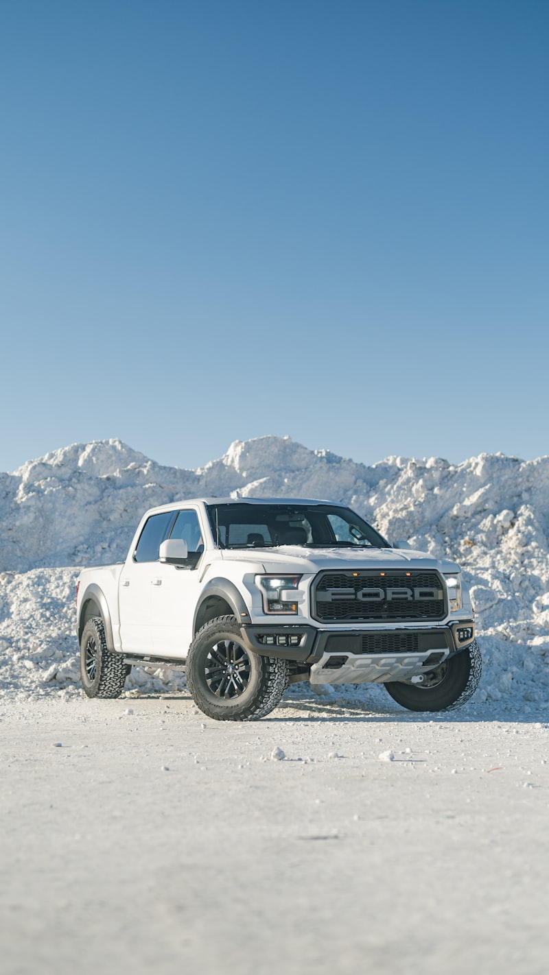 A white Ford pickup truck parked on a snow-covered field