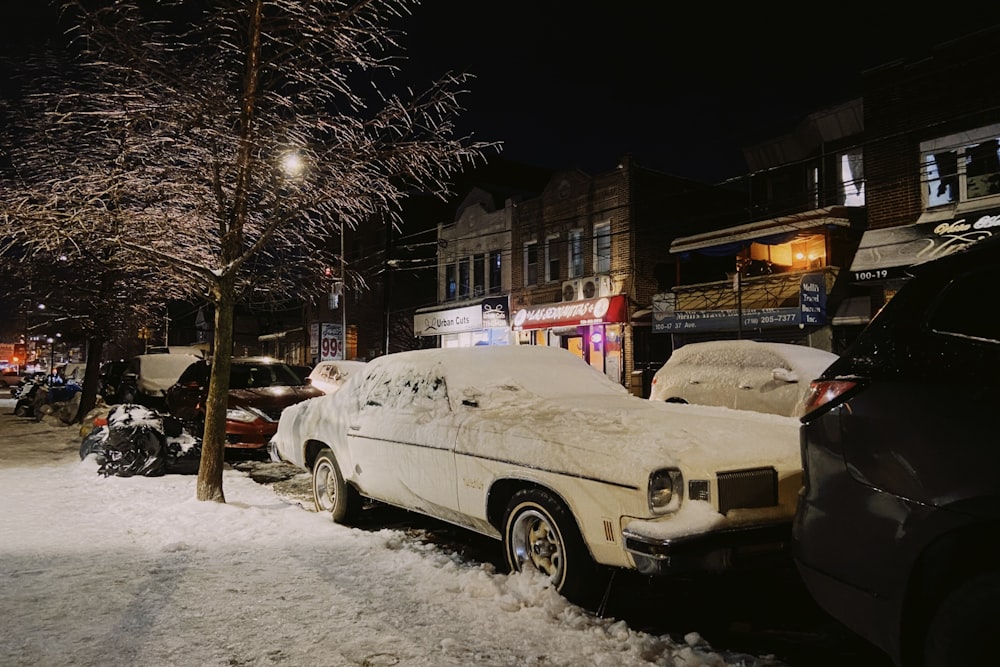 a car covered in snow parked on the side of a street