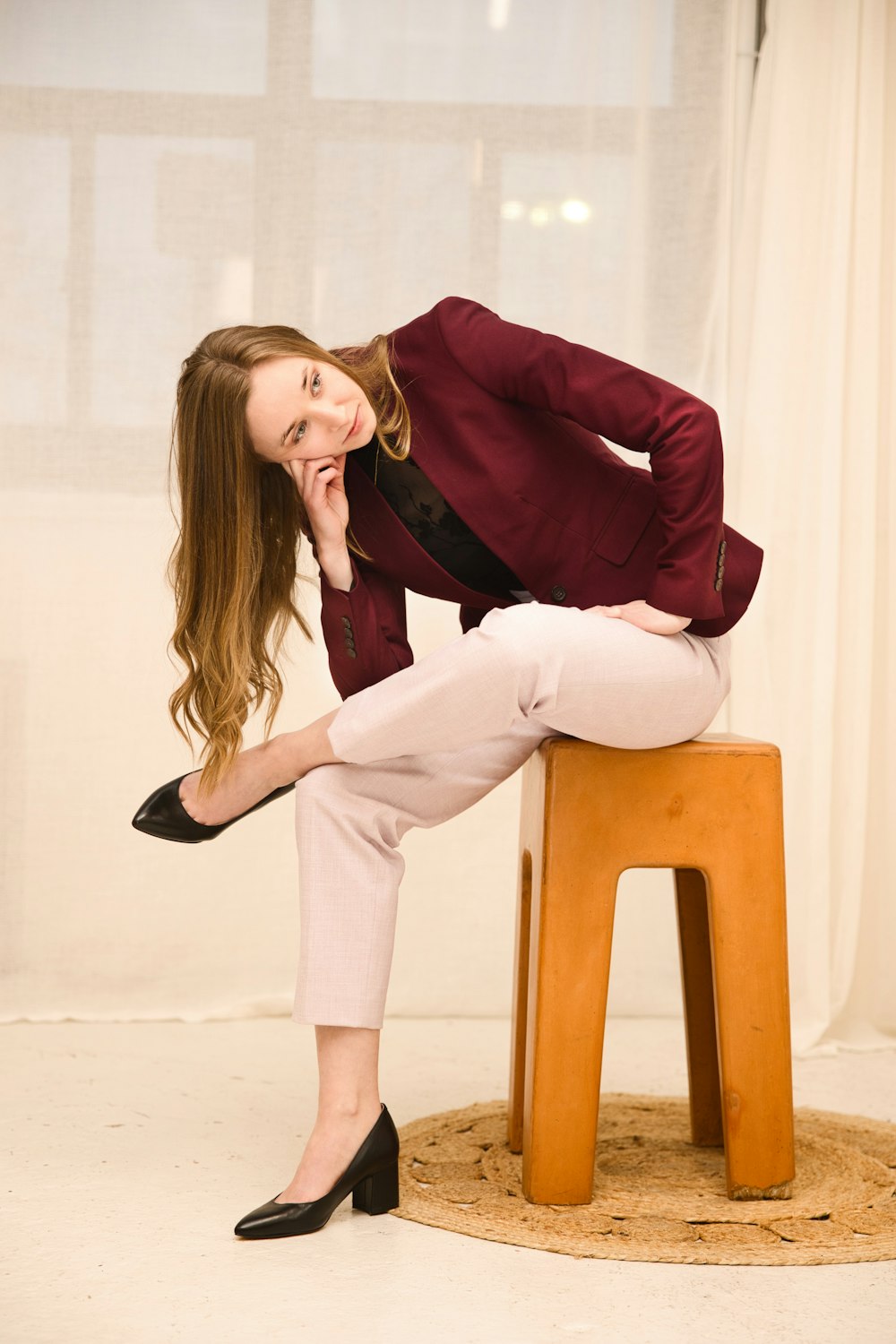 a woman sitting on top of a wooden stool