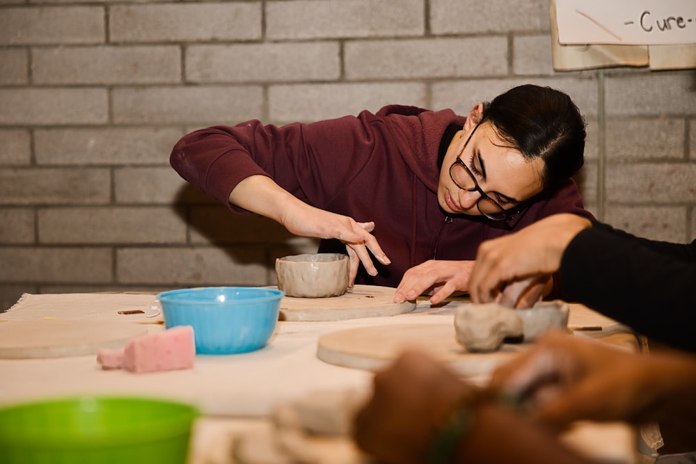 a man and a woman are working on pottery