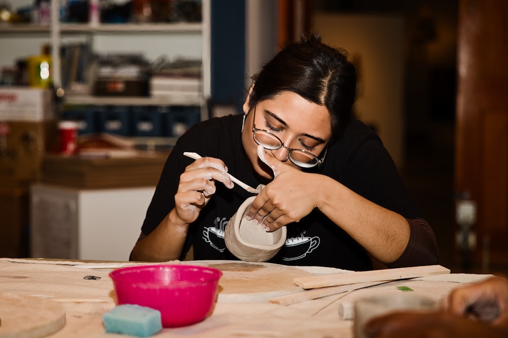 a woman sitting at a table with a bowl and spoon