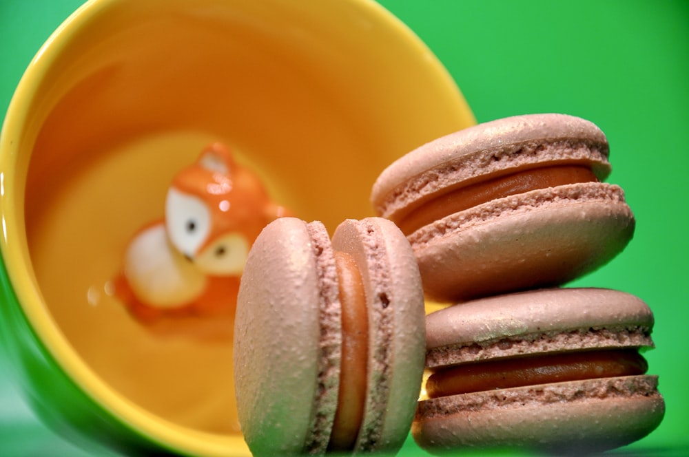 a stack of macaroons sitting in front of a yellow cup