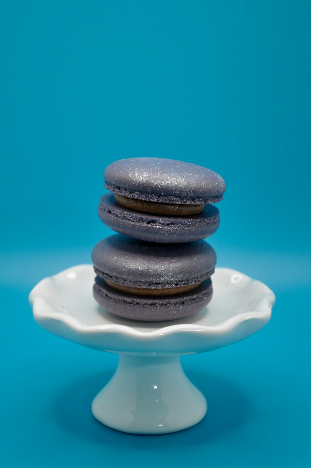 a white plate topped with three cookies on top of a blue background