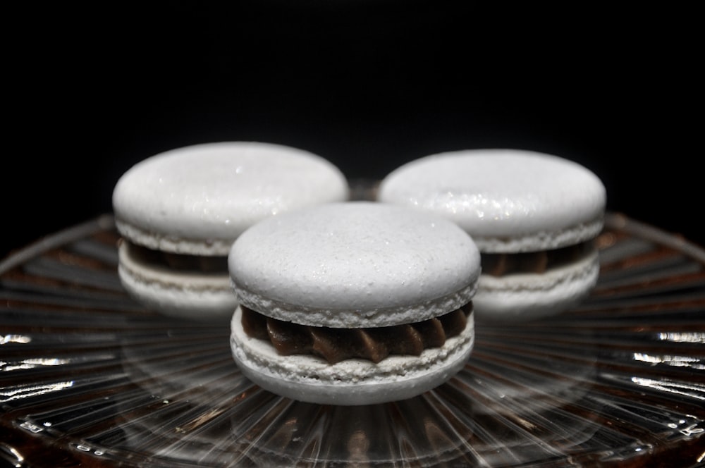 a close up of three pastries on a glass plate