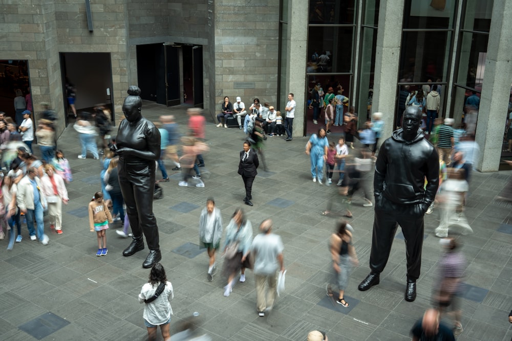 uma multidão de pessoas em pé ao redor de uma estátua de um homem