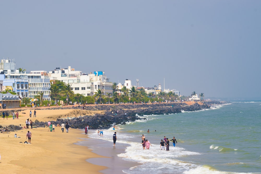 a group of people standing on top of a sandy beach