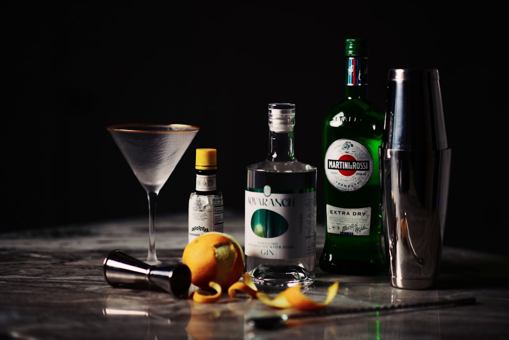 a table topped with bottles of alcohol and a martini glass