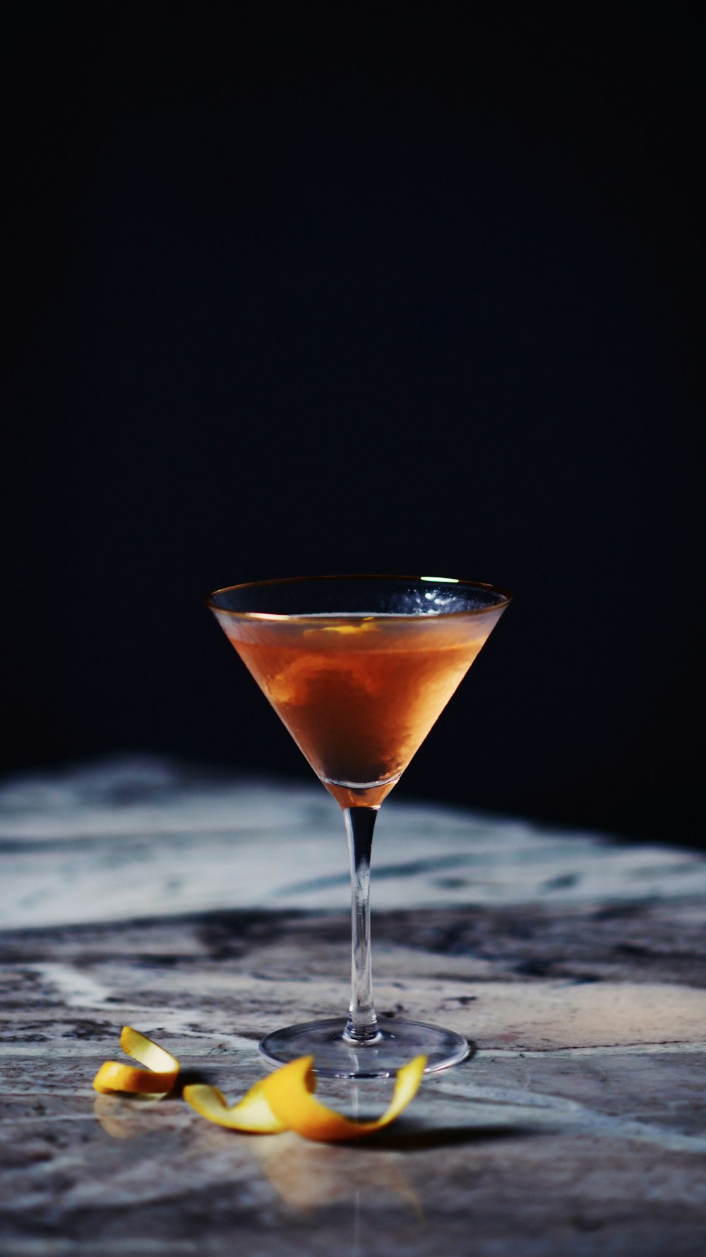 a glass filled with a drink sitting on top of a table