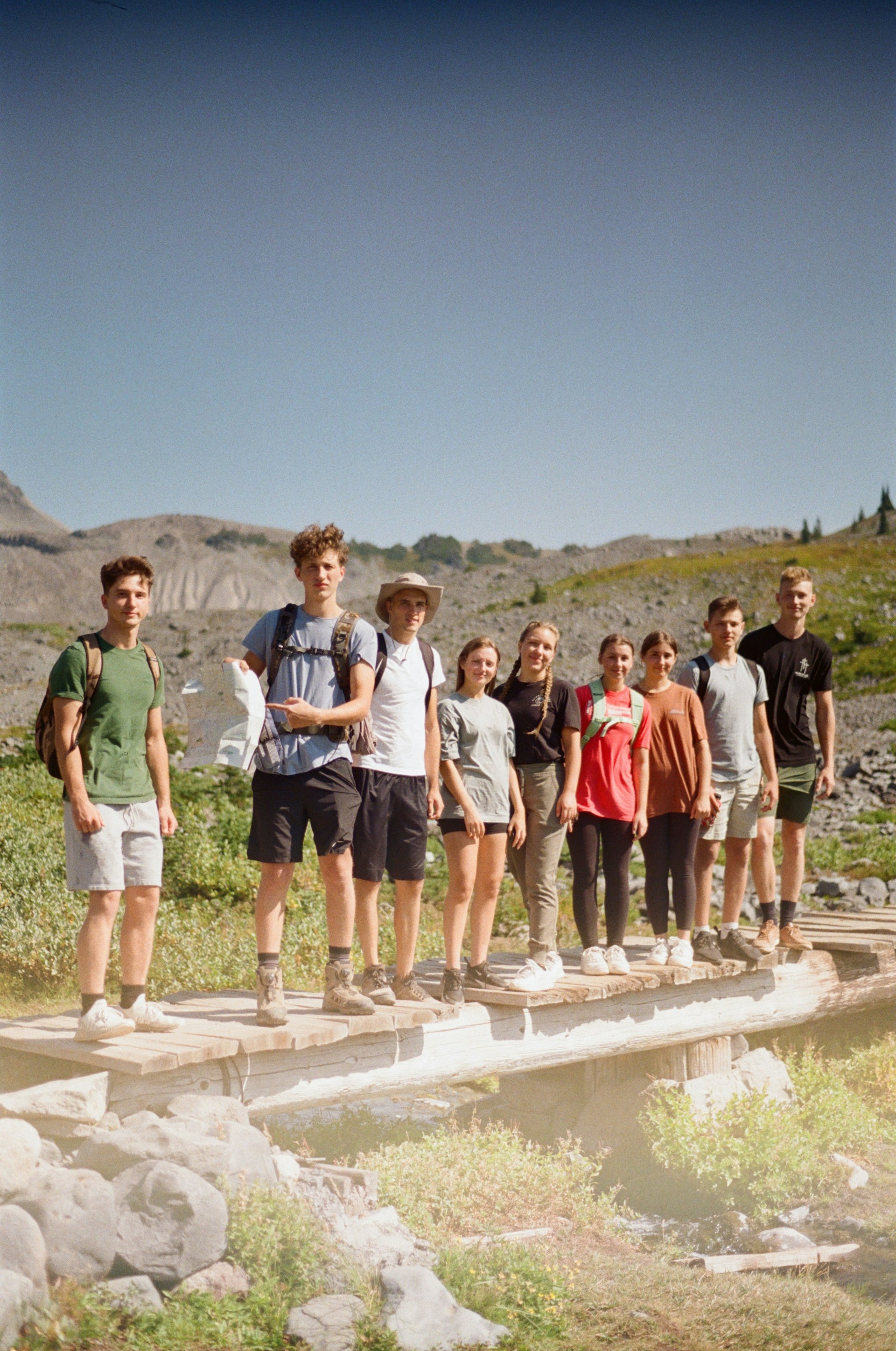 a group of young people standing on a bridge