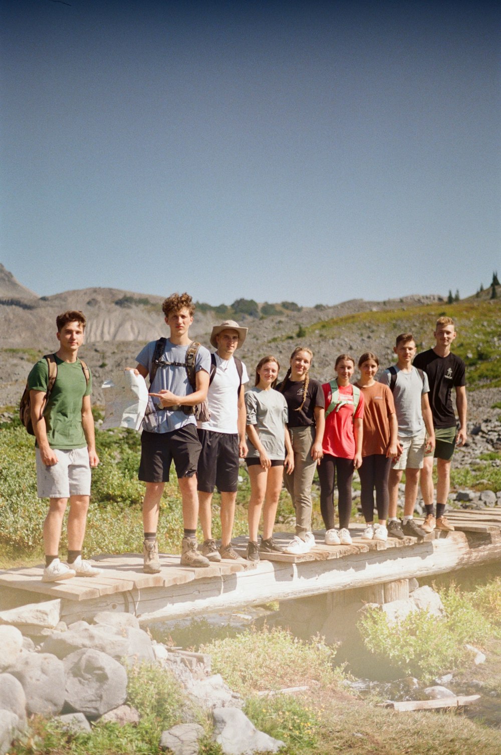 a group of young people standing on a bridge