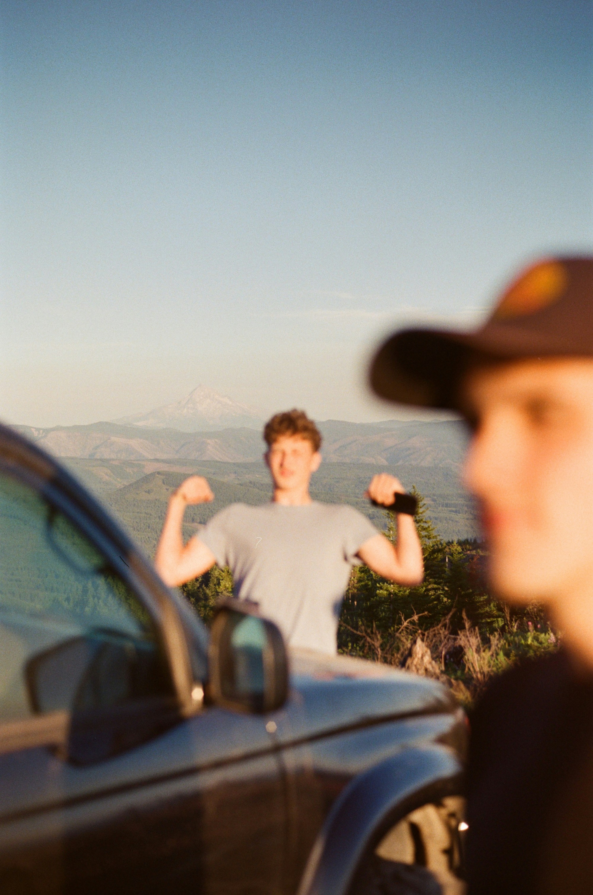 a man standing in front of a car with his fist up