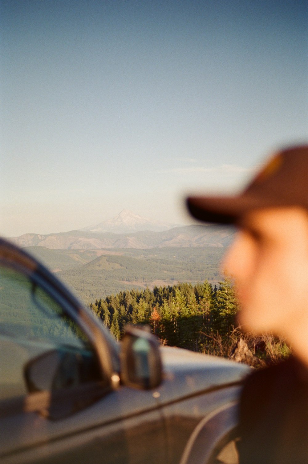 a car driving down a road next to a forest