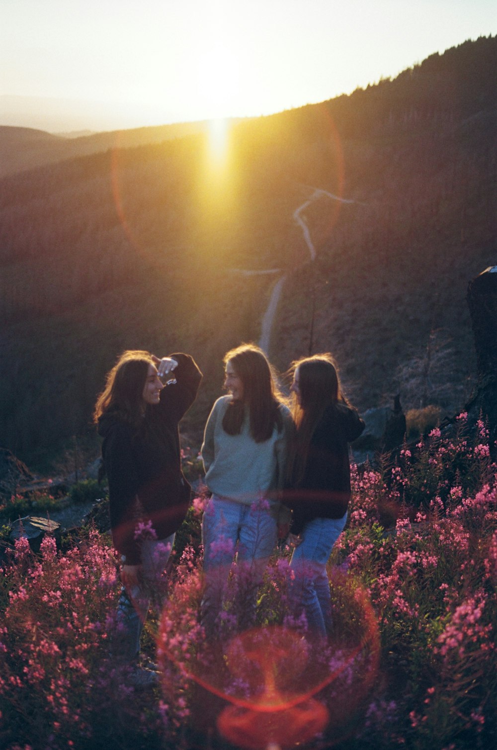 a group of women standing on top of a lush green hillside