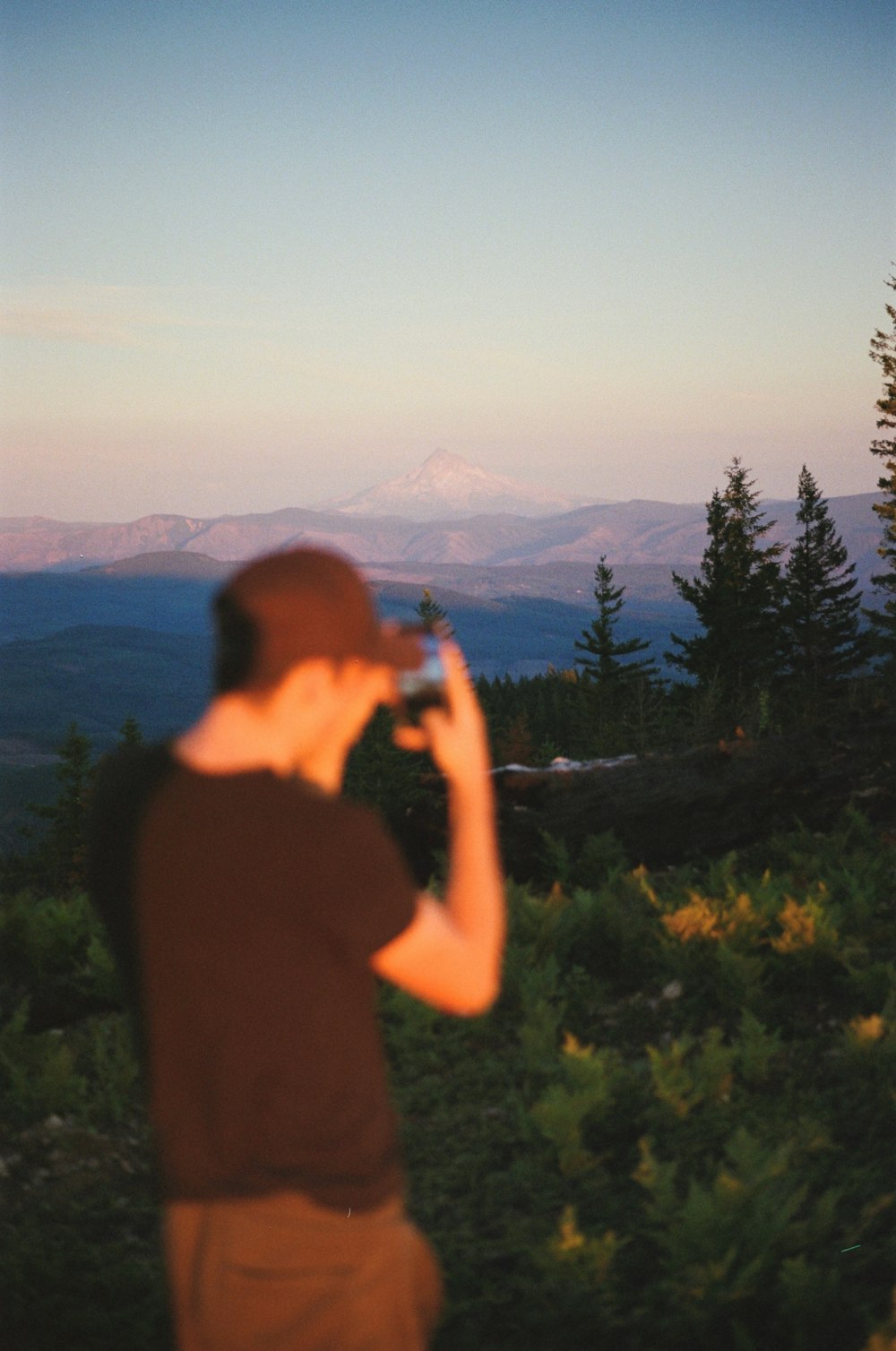 a man standing on top of a lush green hillside