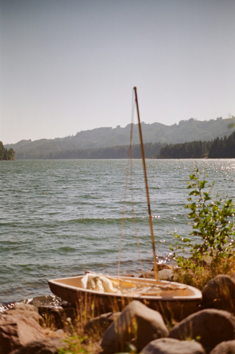 a boat sitting on the shore of a lake