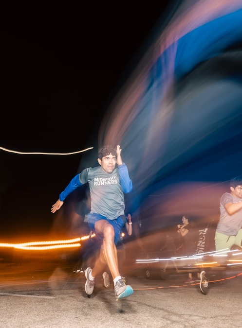 Blurred figure of a man running through city lights after dark