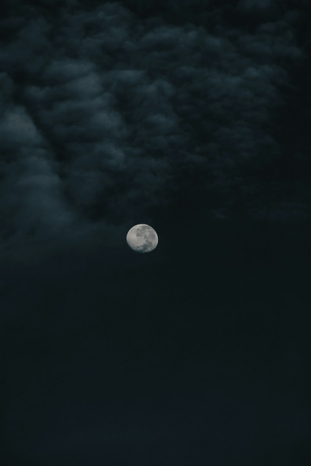 une pleine lune dans un ciel sombre avec des nuages