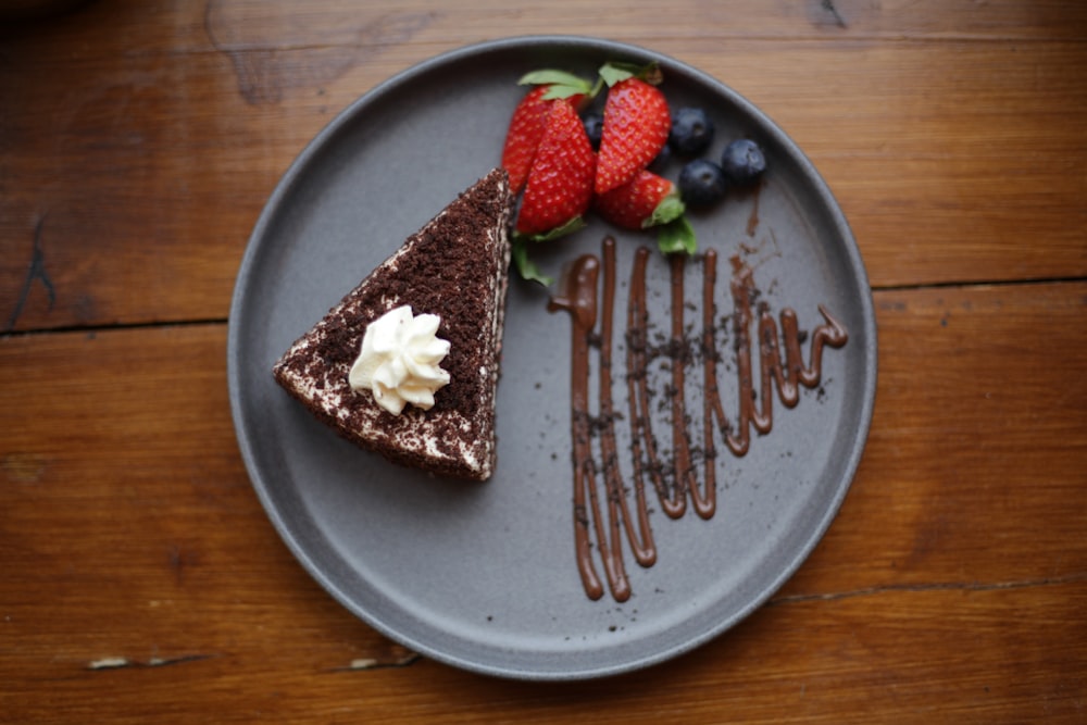 a piece of chocolate cake on a plate with strawberries