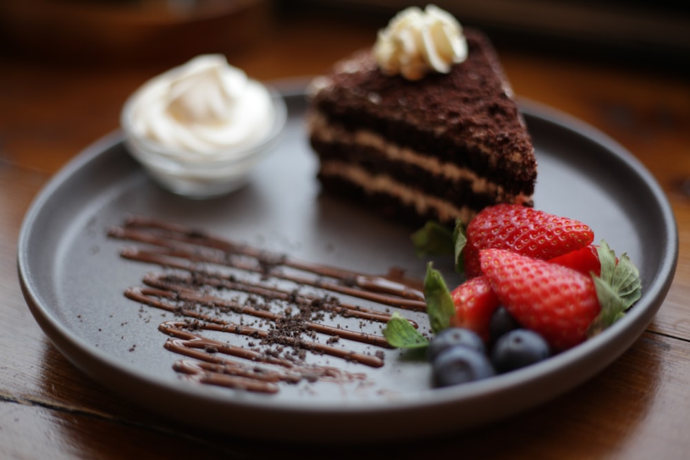 a plate with a piece of cake and berries on it