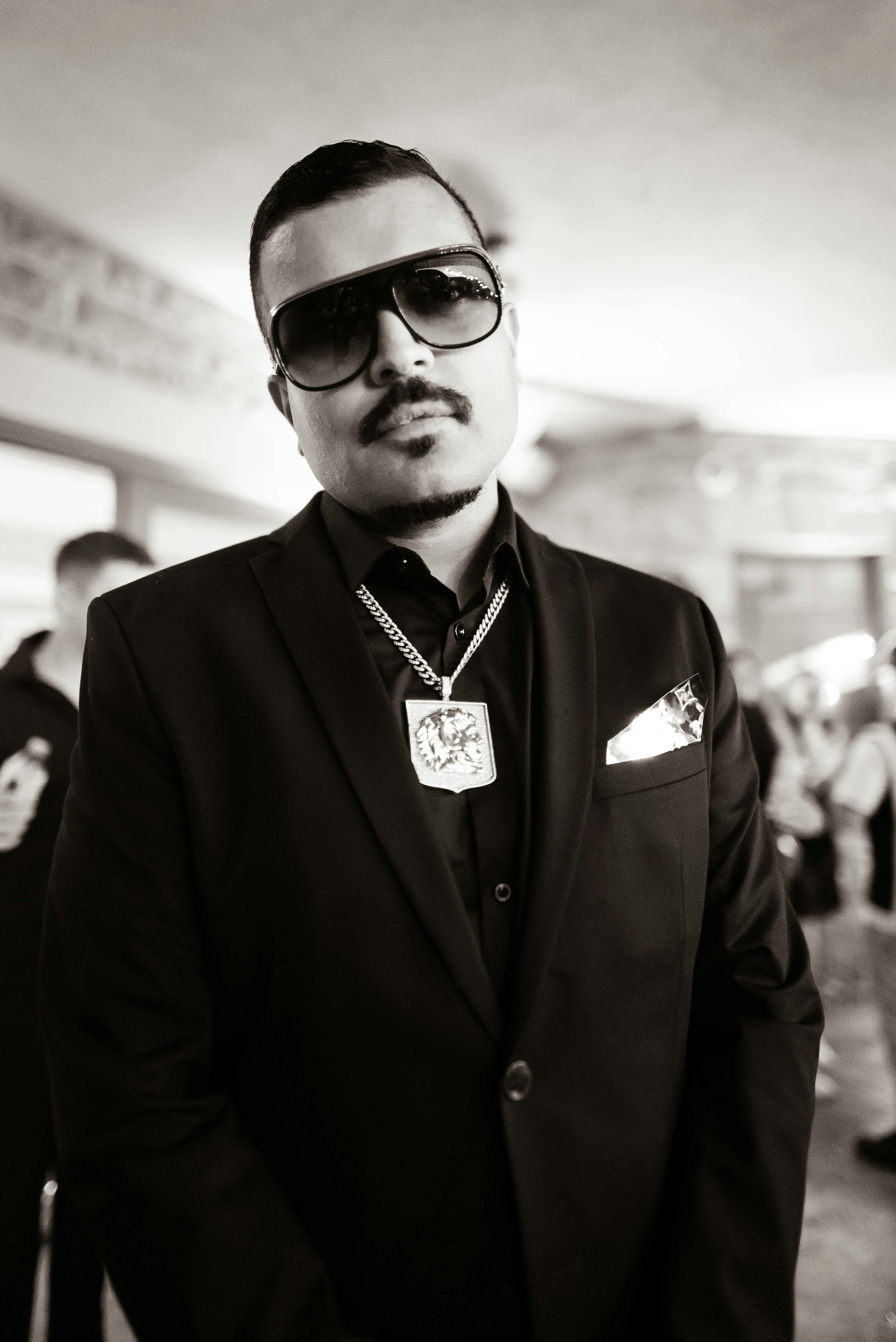 Un homme en costume et lunettes de soleil pose pour une photo