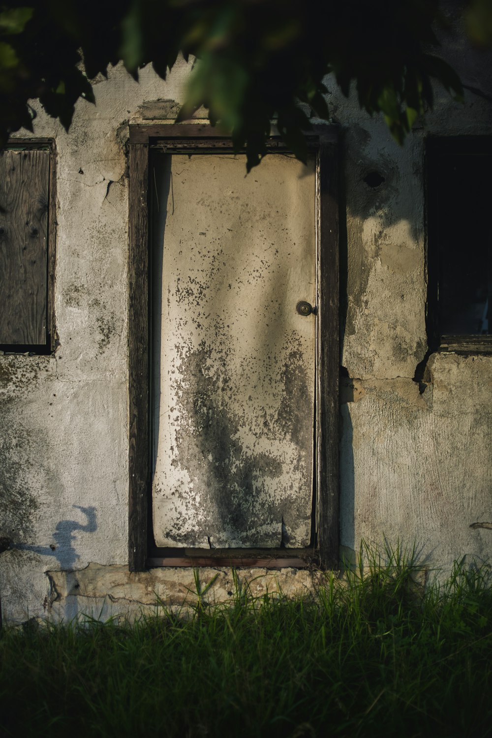 eine alte Tür und ein Fenster eines heruntergekommenen Hauses