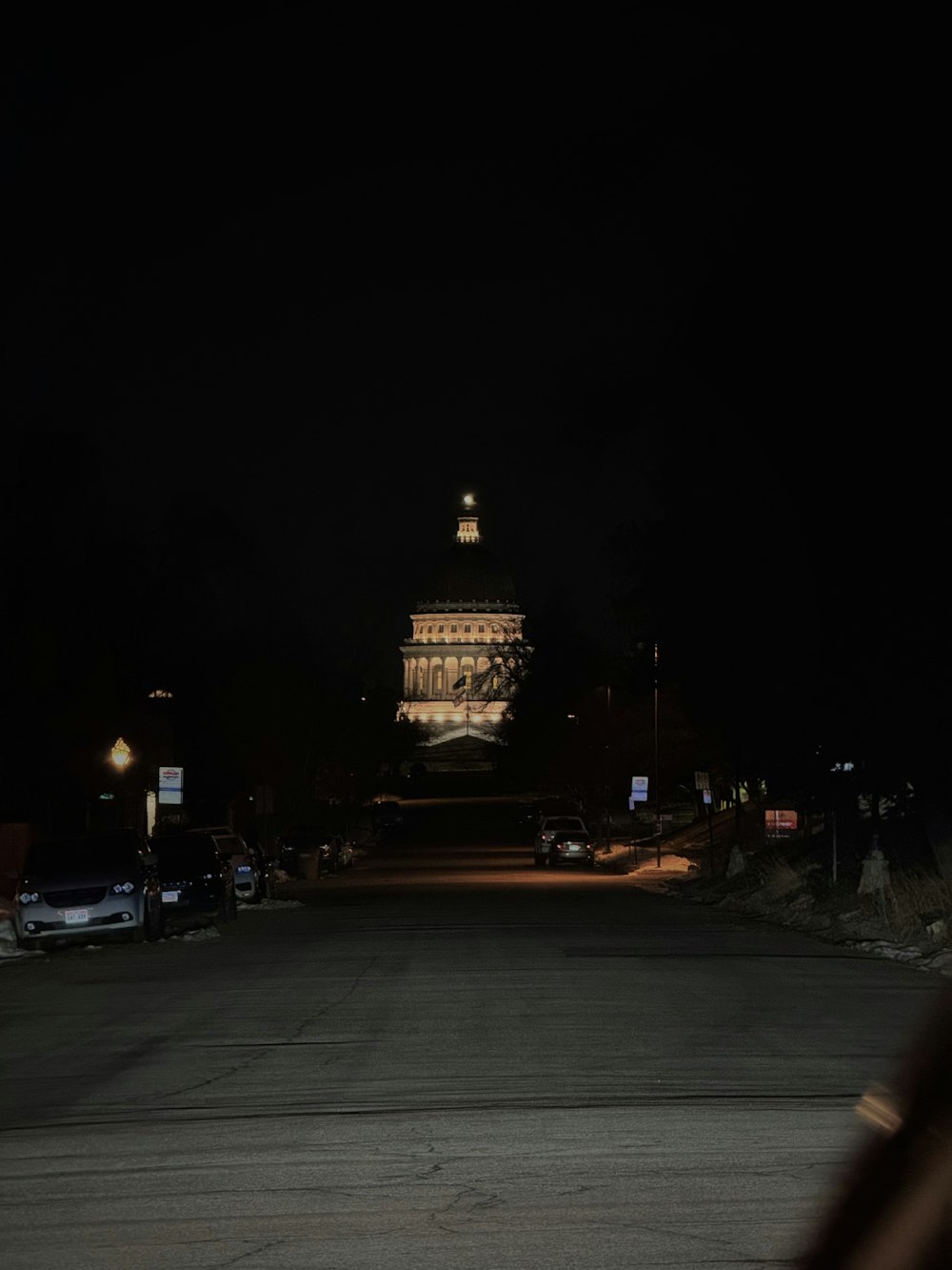 a dark street with a building lit up at night