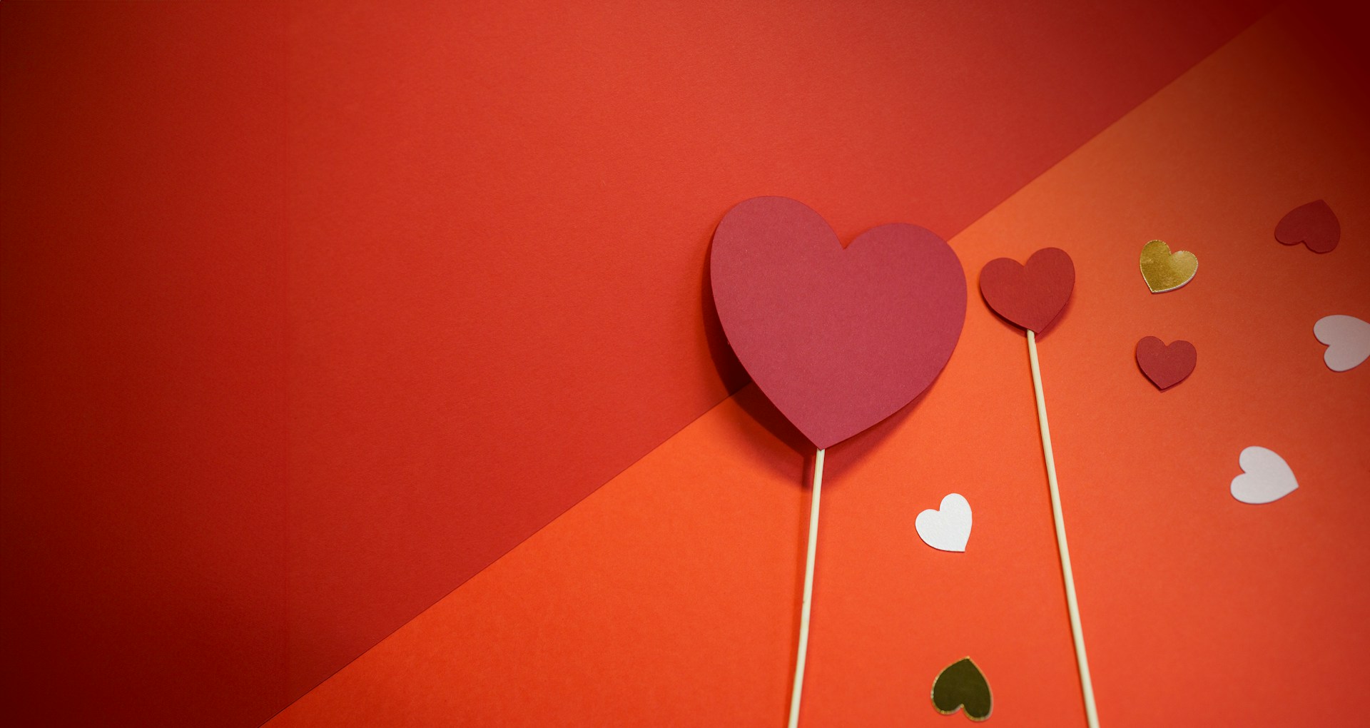 a heart shaped lollipop on a stick on a red and orange background