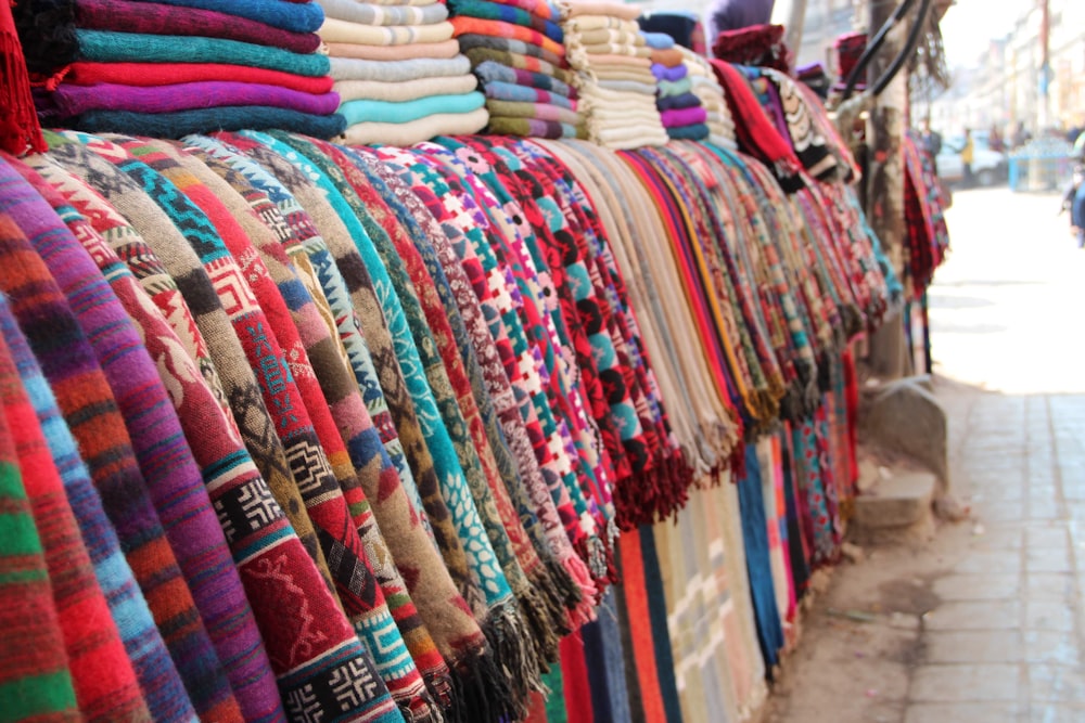 a bunch of sweaters are hanging on a rack