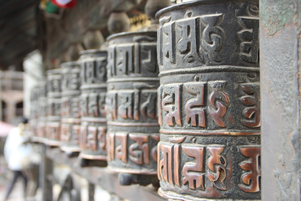 una fila di campane di metallo con scritte asiatiche