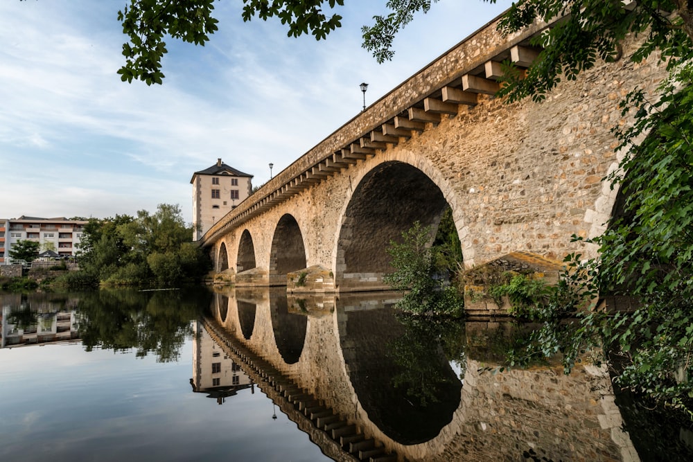 a bridge over a body of water with a building in the background