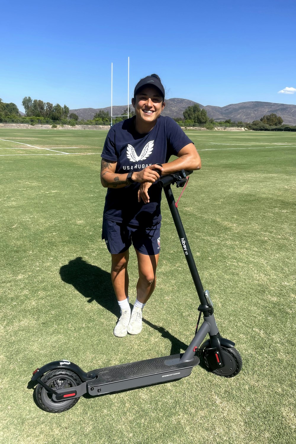 a man standing next to a scooter on a field