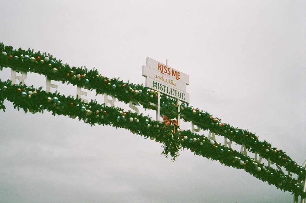 Un cartello stradale decorato con ghirlanda e luci natalizie