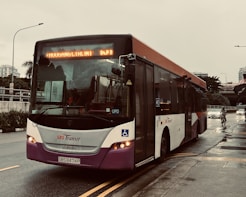 a city bus driving down the street in the rain
