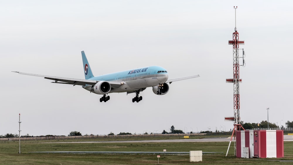 a blue and white airplane taking off from a runway