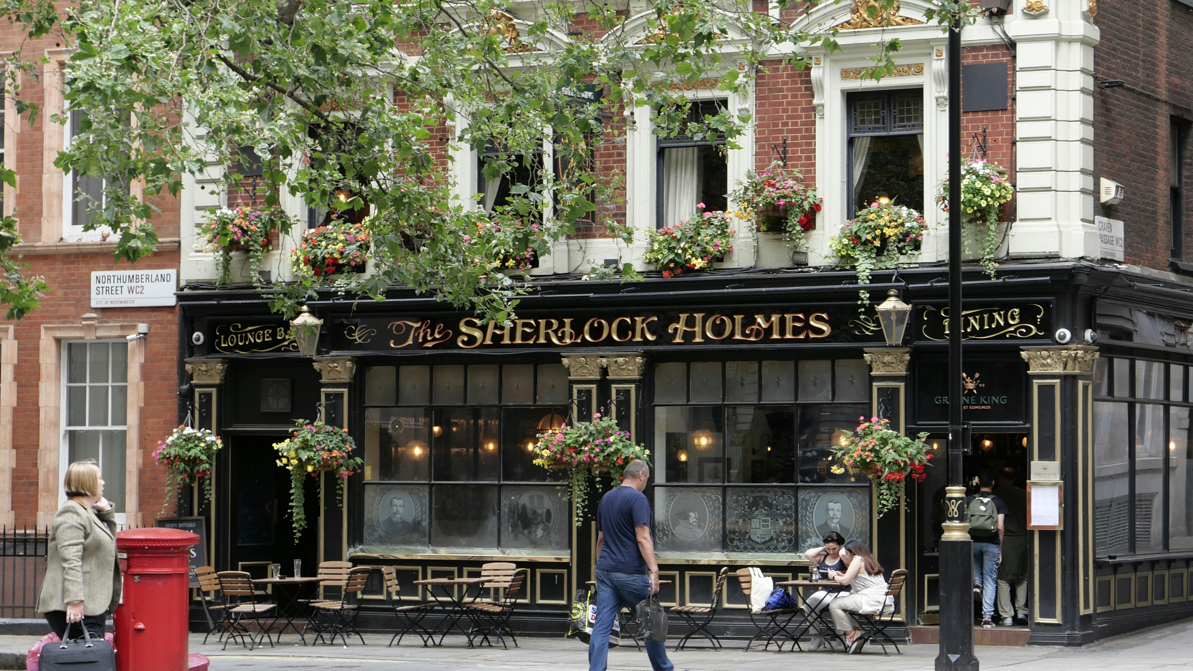 un uomo che passa davanti alla vetrina di un negozio in una strada cittadina