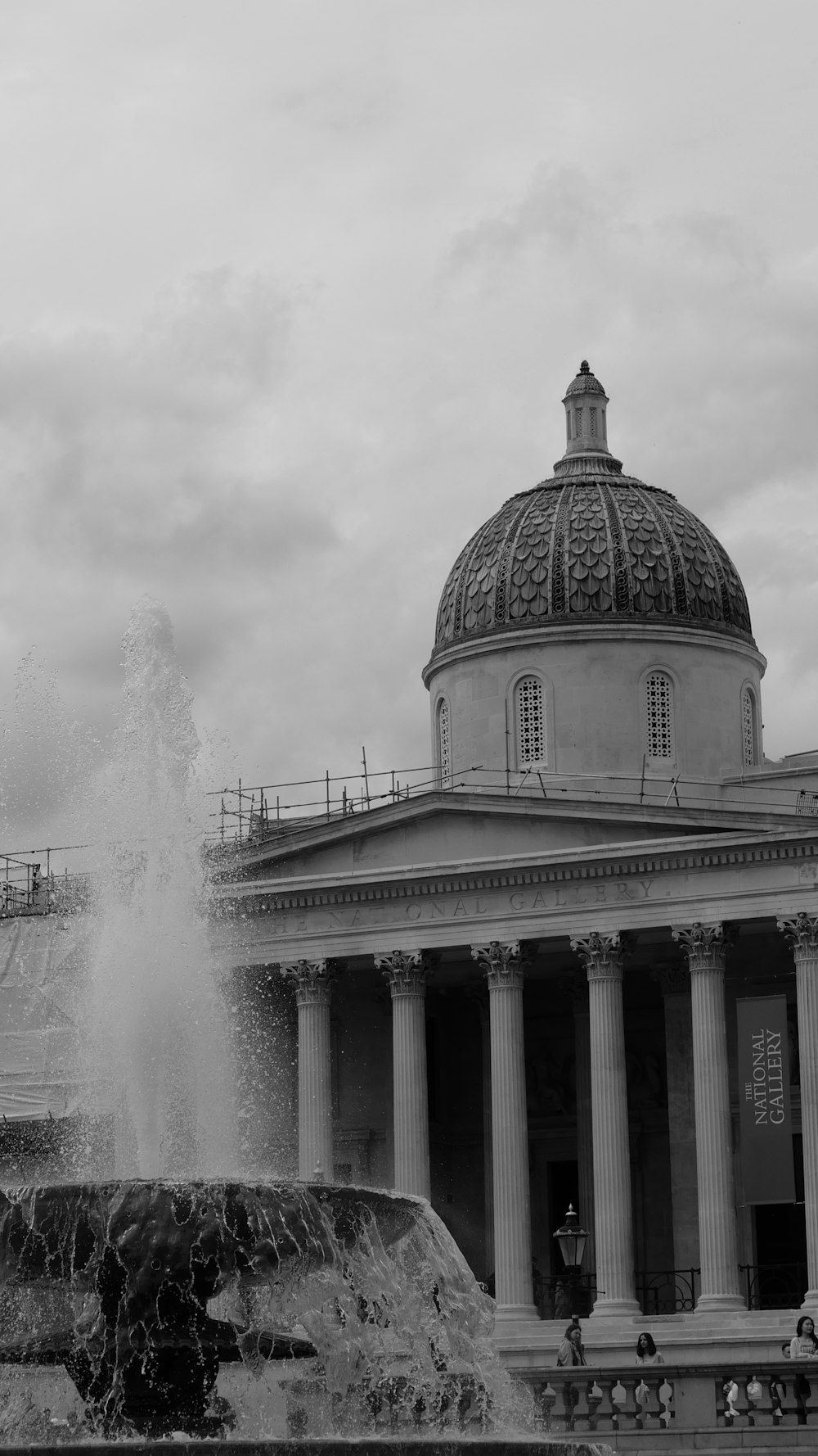 un grande edificio con una fontana di fronte