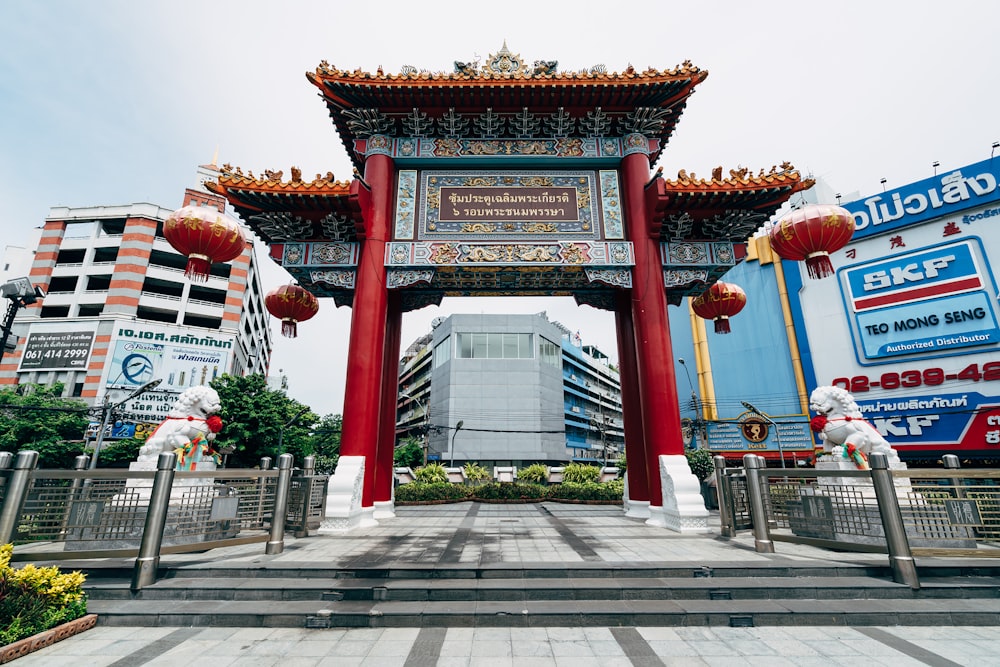 a tall red gate with a sign above it