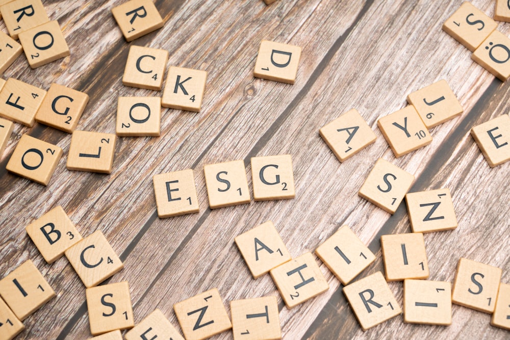 scrabble tiles spelling letters on a wooden surface
