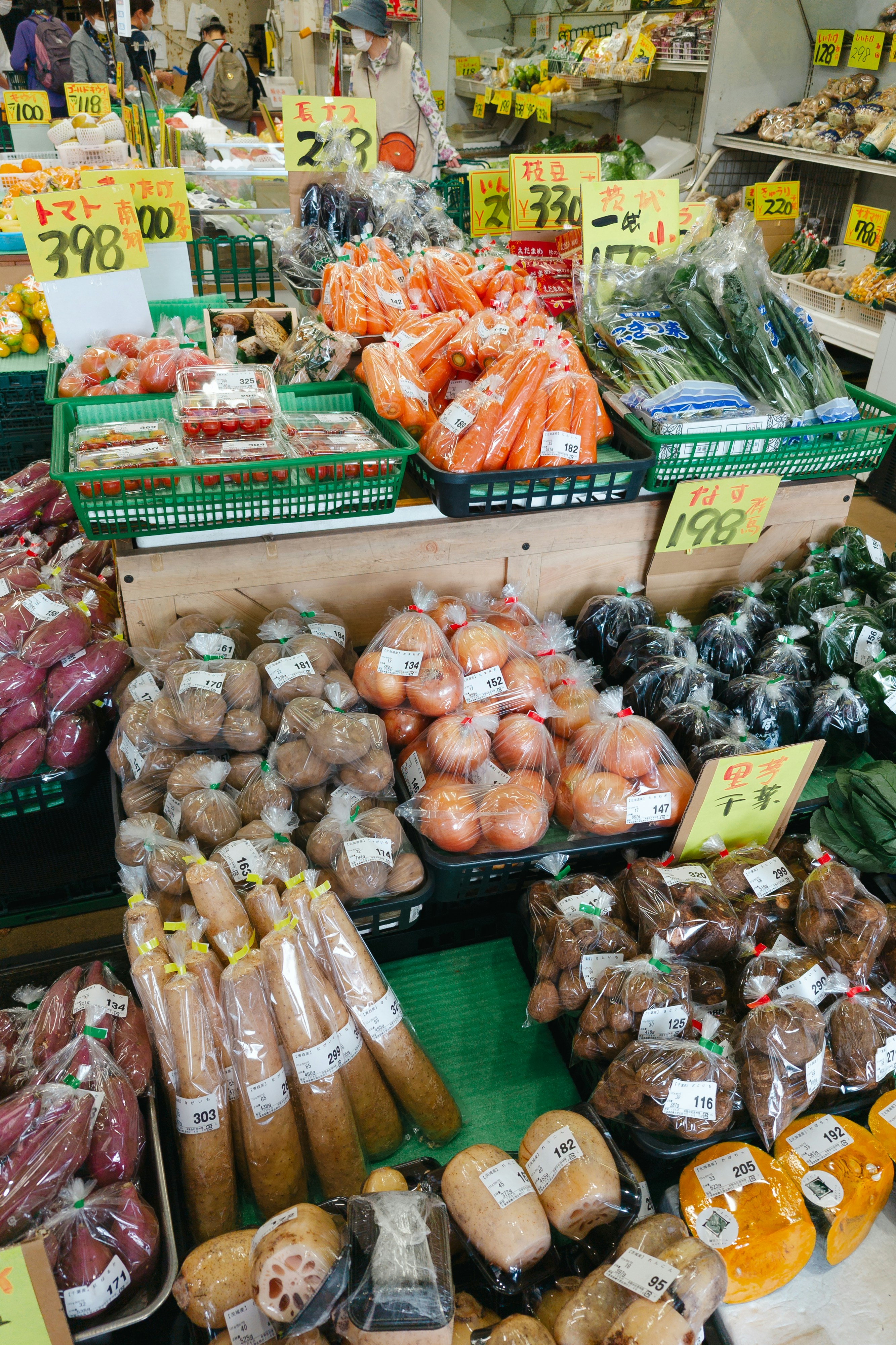 Fresh produce in plastic bags and baskets at a market stall.