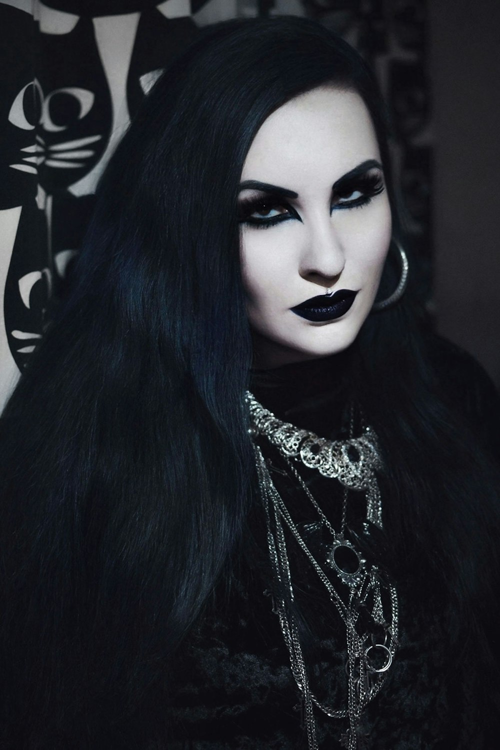a woman with long black hair and black makeup