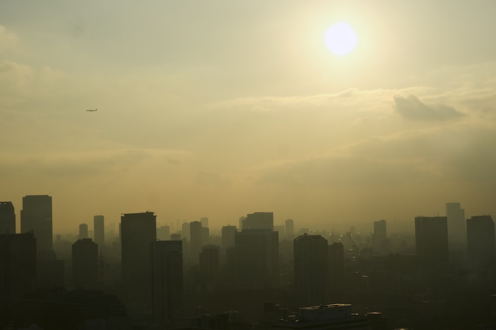 a view of a city with a plane flying in the sky