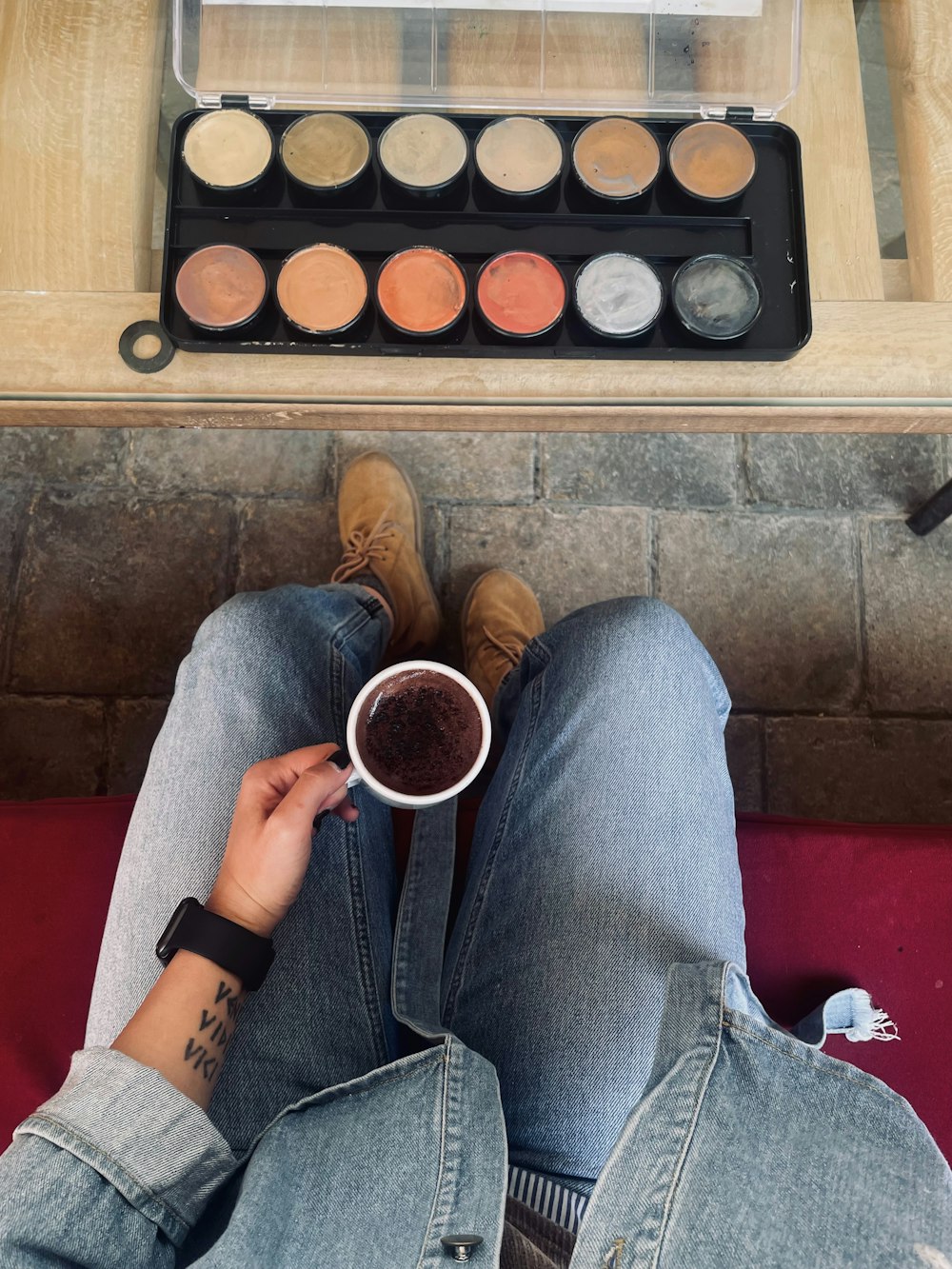 a person sitting on the floor with a cup of coffee