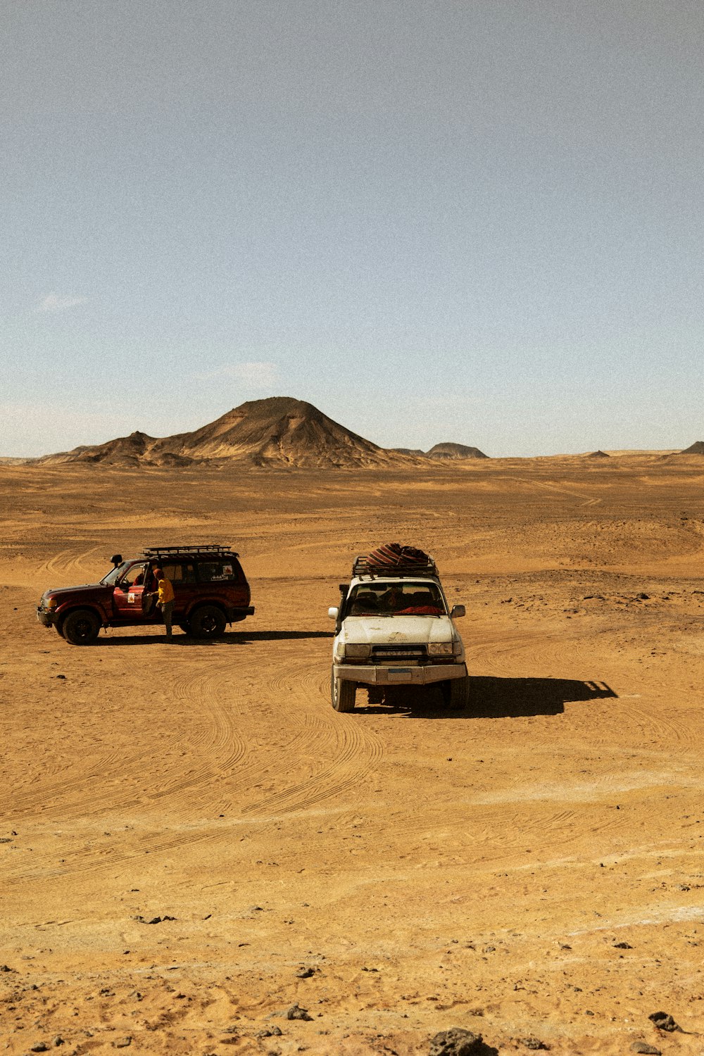 a couple of cars parked in the middle of a desert