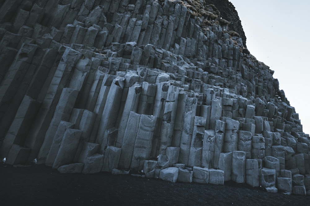 a very tall rock formation with a sky background