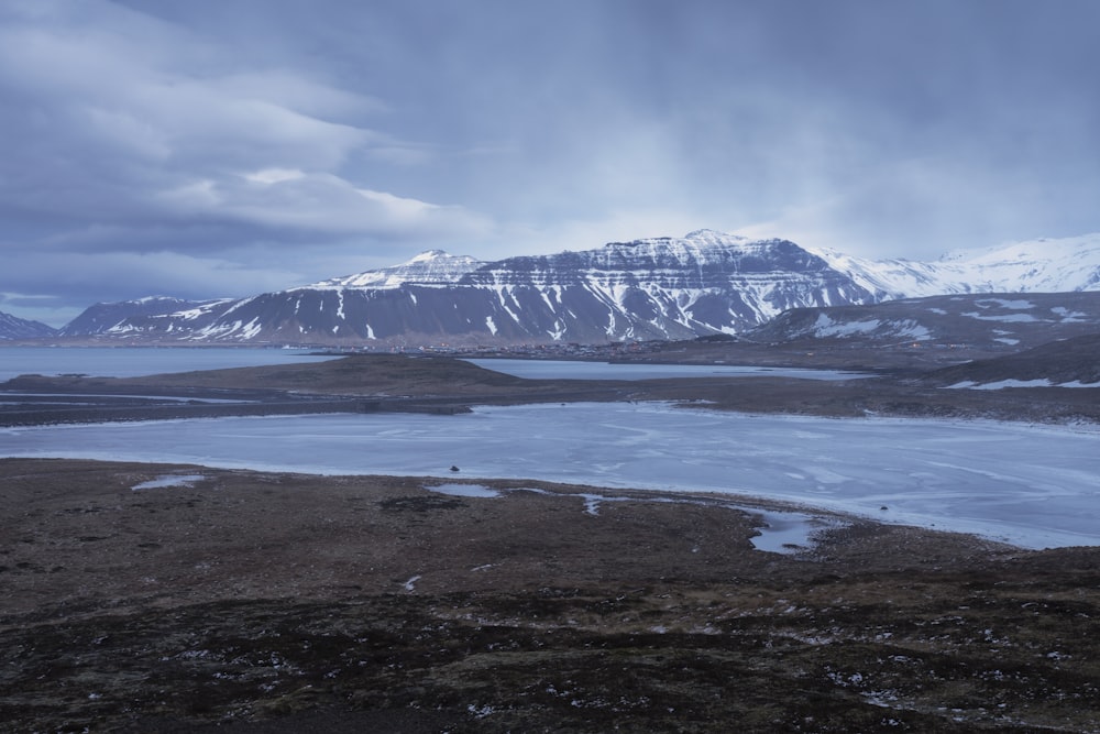 a large body of water surrounded by snow covered mountains