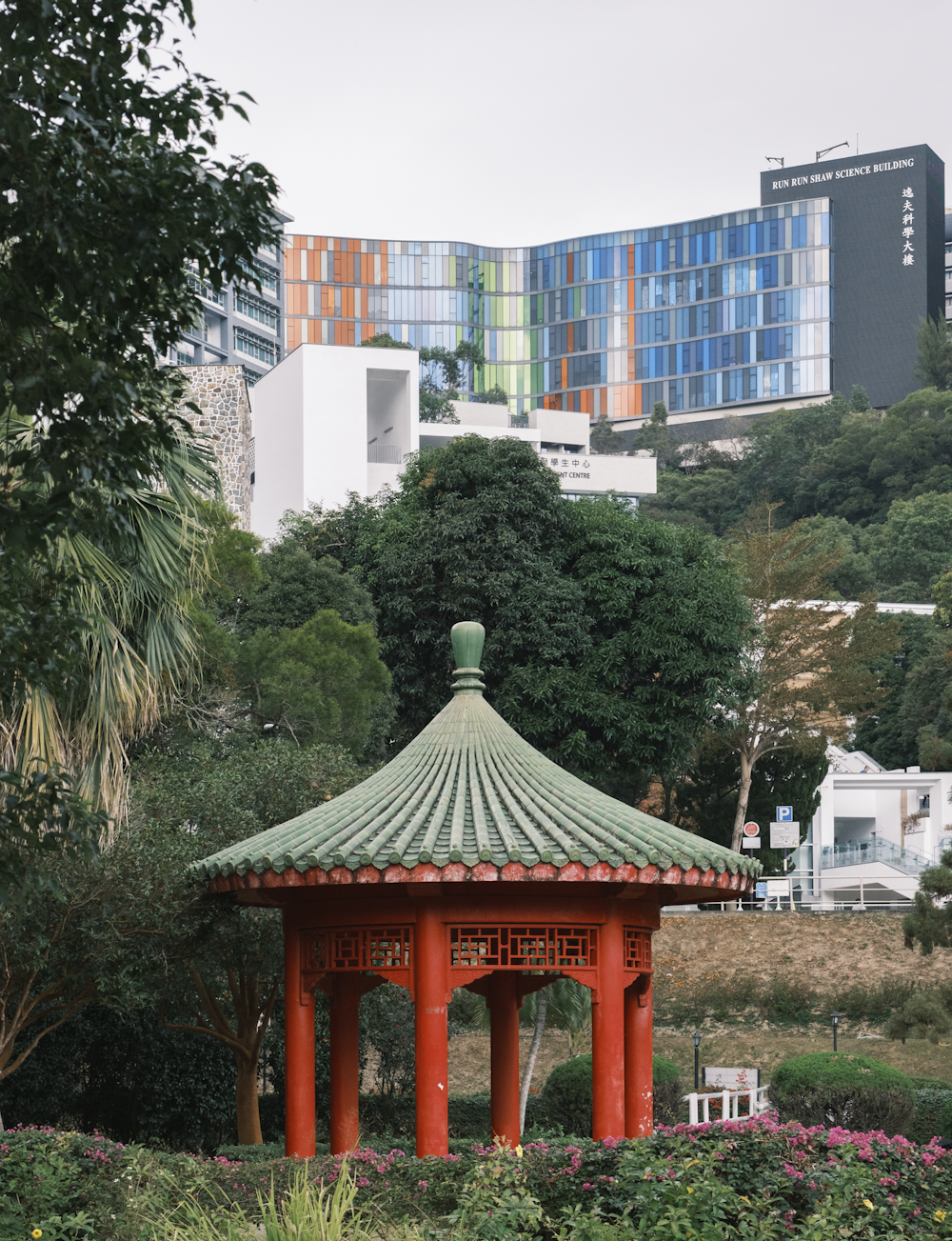 a gazebo in a park with buildings in the background